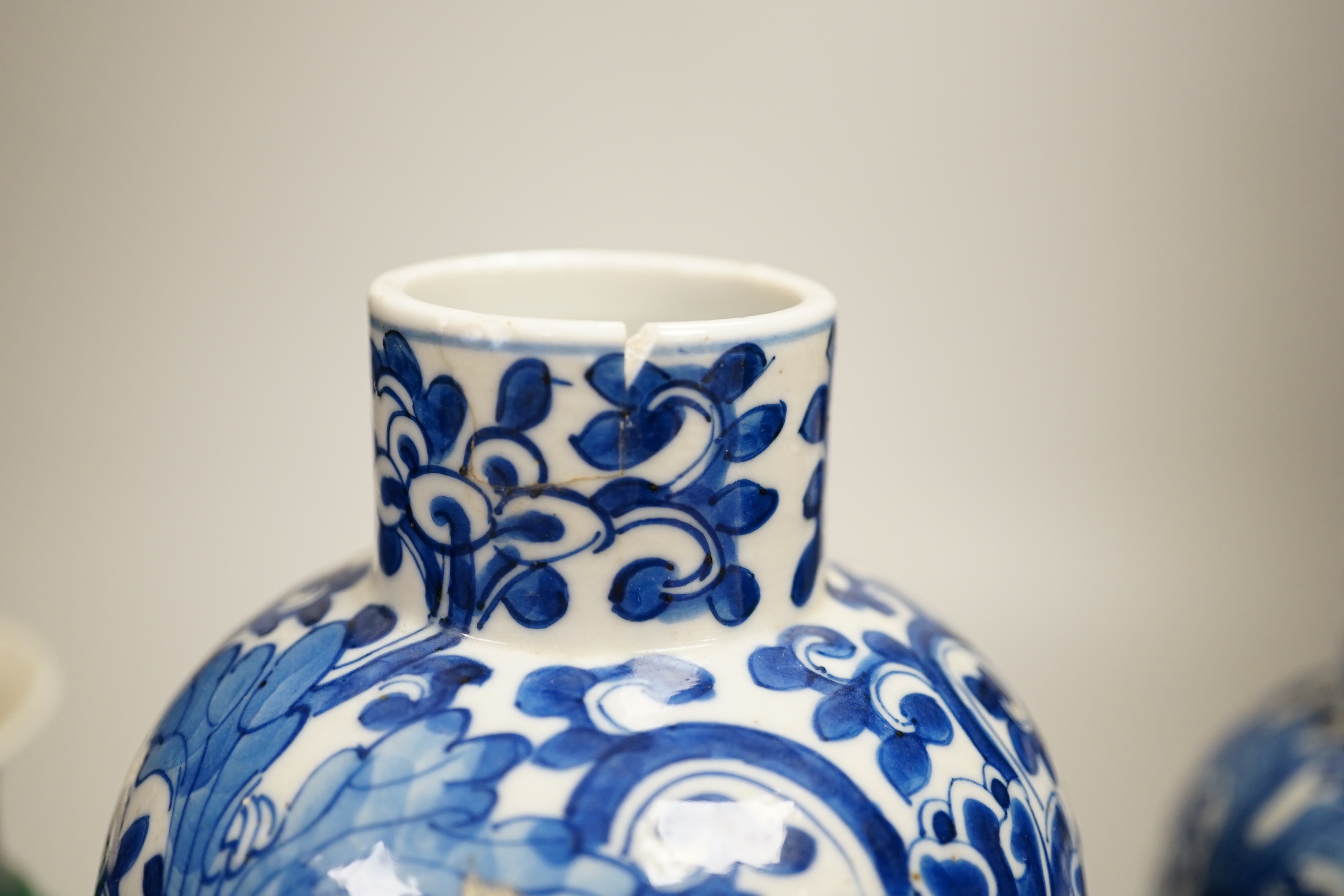 A pair of Chinese blue and white vases and a green glazed vase, blue vases 22.5cm high